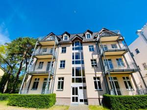 an apartment building with balconies and bushes at Haus Sabine - Ferienwohnung Mine in Ahlbeck