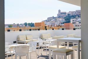El Puerto Ibiza Hotel Spa في مدينة إيبيزا: مجموعة طاولات وكراسي على السطح