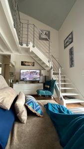 a living room with a couch and a staircase at Villa Indépendante tout confort Soustons Plage Golf à 900m wifi Bbq in Soustons