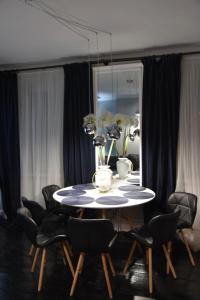 a dining room table with black chairs and a mirror at Warszawska Apartament Rajgród in Rajgród