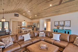 a living room with a brown leather couch at Quiet Mtn Cabin with Deck Less Than 5 Mi to Fairplay Beach! in Fairplay