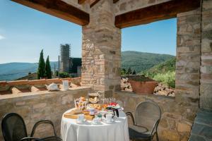 uma mesa e cadeiras num pátio com vista em Rocca Di Pierle Agriturismo di Charme em Mercatale