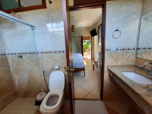 a bathroom with a toilet and a sink at Residencial Villafranca in Boicucanga