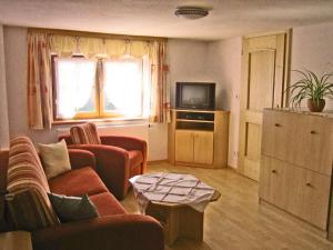 uma sala de estar com um sofá e uma televisão em Haus Zaineck em Anger