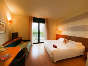 a hotel room with a white bed and a window at Phi Hotel Emilia in Ozzano dell Emilia