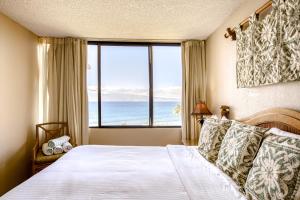 een slaapkamer met een bed en een groot raam bij Kaanapali Shores 806 in Kaanapali +21 foto's