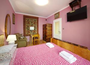 - une chambre aux murs roses et un lit avec 2 serviettes dans l'établissement Apartament Polski Free Guarded Parking, à Varsovie