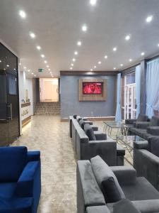 a waiting room with couches and a screen in a building at Perla Del Mar Aparthotel in Lozenets