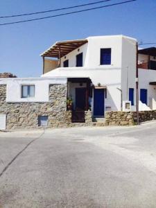 a white house with blue doors on a street at Mykonian beauty(beach spot) in Platis Yialos Mykonos