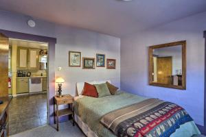 1 dormitorio con cama y espejo y cocina en Downtown Cabin Less Than 10 Miles to Mt Shasta Ski Park!, en McCloud