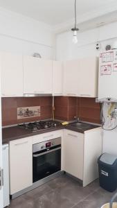 a kitchen with white cabinets and a stove top oven at Seawave Beach in Constanţa