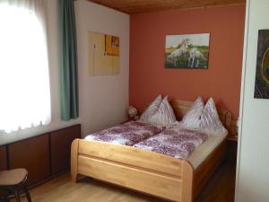 Ferienwohnungen Pernull في Waidegg: غرفة نوم بسرير وصورة خيول على الحائط