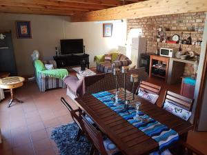 uma sala de estar com uma mesa de madeira e cadeiras em Loeriehuis em George