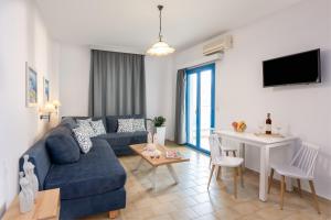 a living room with a blue couch and a table at Nana Angela Apartments in Hersonissos