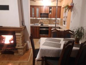 a kitchen with a table and a fireplace in a room at Domek Regionalny- bliźniak in Baligród