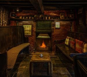a living room with a fireplace and a couch and a table at The Leagate Inn in Coningsby
