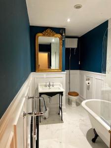 a bathroom with a sink and a mirror and a tub at The Leagate Inn in Coningsby