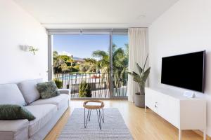 ein Wohnzimmer mit einem weißen Sofa und einem Flachbild-TV in der Unterkunft Apartment with Mount Teide and sea views in Santa Úrsula