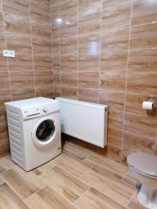 a washing machine in a bathroom with a toilet at Kerka Szállás in Kerkabarabás +53 photos