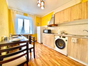 a kitchen with a table and a washing machine in it at ApartPoltava ЦЕНТР Полтави, Простора та зручна квартира біля ПУЕТ, 2-ОКРЕМІ КІМНАТИ, звітна документація для відрядження in Poltava +15 photos