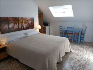 1 dormitorio con 1 cama, mesa y sillas en Hostal Las Encinas en Villaviciosa de Odón