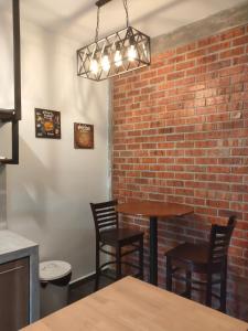 a brick wall in a restaurant with a table and chairs at Just Austin Guesthouse in Ipoh