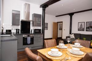 cocina y comedor con mesa y sillas en 27 Stanley Street Aparthotel by UStay, en Liverpool