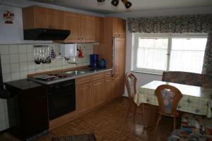 a kitchen with wooden cabinets and a table and a window at Kastnerhof 