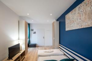 un salon avec un mur d'accent bleu dans l'établissement Le Musigny - Superbe studio moderne au calme proche place Valmy, à Lyon