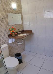 a bathroom with a toilet and a sink at Pousada Águas do Forte in Cabo Frio