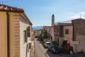 an alley with cars parked on a street with a clock tower at DIANA in Crikvenica
