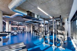 a gym with blue flooring and a large room with machines at Highfield House in Dublin