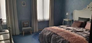 a blue bedroom with a bed and a chair at Close to centre, 3 rooms, 2 bathr & wc, free parking & wifi, spacious living area & kitchen in Bruges