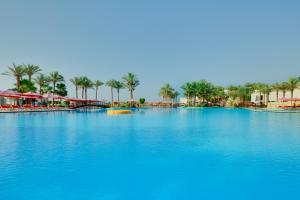 een groot zwembad van blauw water met palmbomen bij Grand Rotana Resort & Spa in Sharm El Sheikh