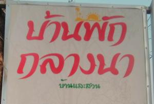 una señal de jamjadjadjadjad escrita en rojo en una señal blanca en บ้านพักกลางนา en Amphoe Sawang Daen Din