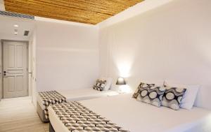 a bedroom with two beds and a wooden ceiling at Thomais Studios in Naxos Chora