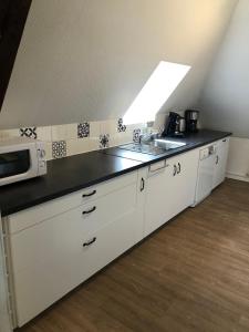 een keuken met een wastafel en een magnetron bij Chez Jules ,Parking gratuit, 3ème Etage in Saint-Valery-sur-Somme