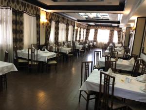 uma sala de jantar com mesas e cadeiras com toalhas de mesa brancas em Hotel Onix em Roman
