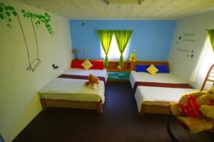 1 Schlafzimmer mit 2 Betten und 2 Fenstern in der Unterkunft 珊瑚礁民宿 in Magong