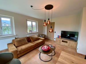 a living room with a couch and a tv at Vakantiehuis Cas.tard in Zillebeke