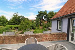 eine Terrasse mit 2 Stühlen und einer Ziegelwand in der Unterkunft Adlerlodge - Ferienhaus in Michelstadt