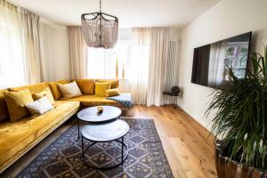 ein Wohnzimmer mit einem gelben Sofa und einem Tisch in der Unterkunft Adlerlodge - Ferienhaus in Michelstadt