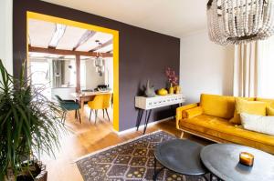 ein Wohnzimmer mit einem gelben Sofa und einem Tisch in der Unterkunft Adlerlodge - Ferienhaus in Michelstadt