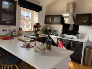 a kitchen with a counter with a vase of flowers on it at Saddleback Penthouse in Penrith