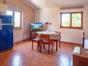 a kitchen with a table and chairs and a tv at Studio Apartment Gianni in Vižinada