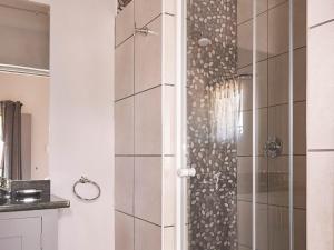 La salle de bains est pourvue d'une douche avec une porte en verre. dans l'établissement Highland Quarters, à Clarens