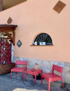 two red chairs and a table next to a wall at Da Artù in Cittaducale