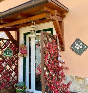 uma porta da frente de uma casa com flores vermelhas em Da Artù em Cittaducale
