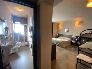 Habitación con baño con cama y lavabo. en Hotel Le Badie, en Val di Perga
