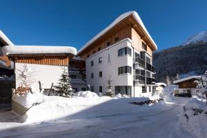 ein Gebäude mit Schnee auf dem Boden davor in der Unterkunft Alpenleben in Sankt Anton am Arlberg